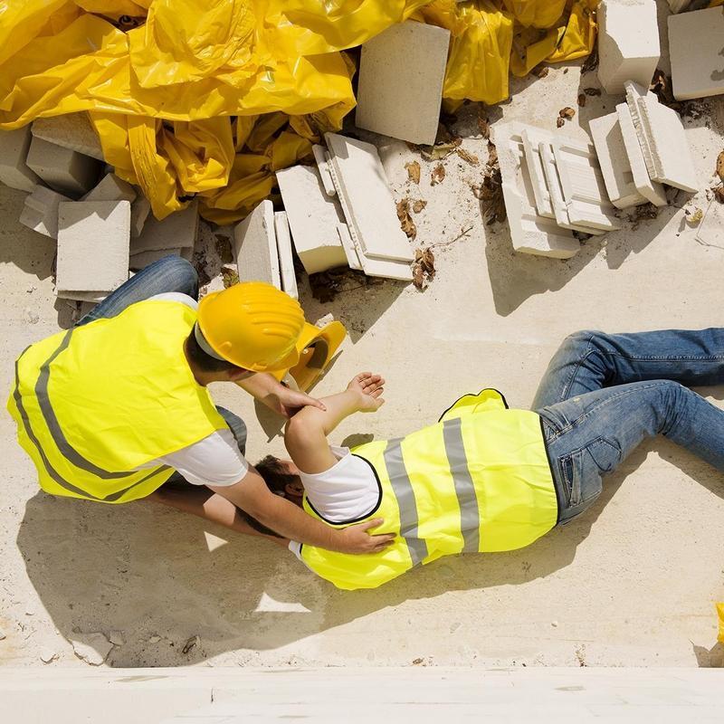 Construction worker rescuing colleague who passed out